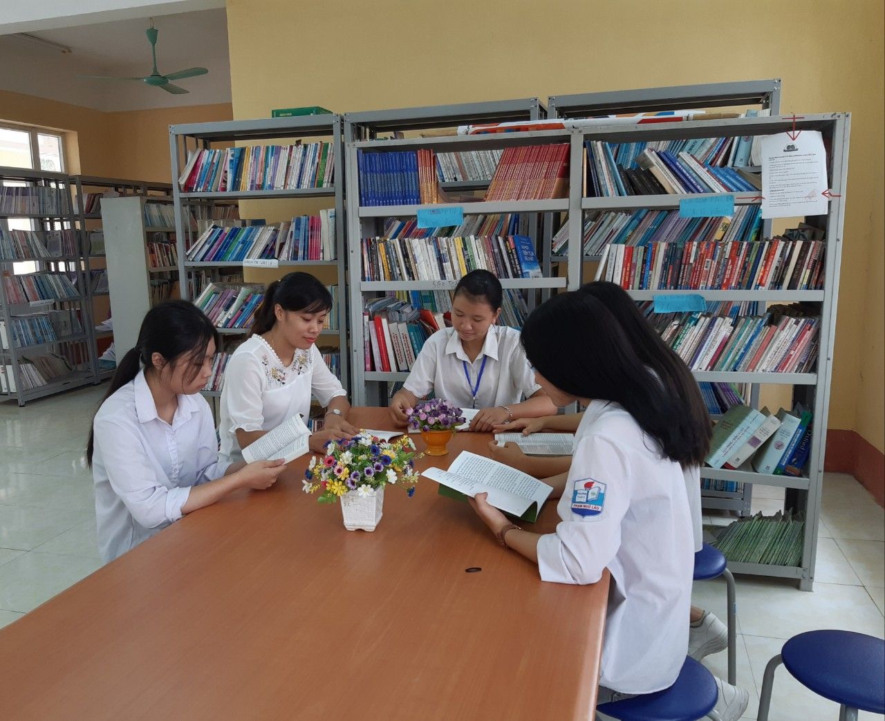Giáo viên chủ nhiệm lớp cùng học sinh đọc sách tại phòng Thư viện trường THPT Phạm Ngũ Lão